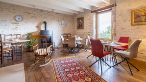 Un coin repas au style rustique, avec un plancher en bois, un tapis à motifs et un mélange de chaises traditionnelles et modernes.