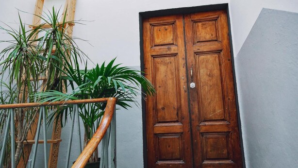 A wooden door, a staircase, and potted plants. - Apartment 'Borgo Pinti 49' with Private Terrace, Wi-Fi and Air Conditioning (Florence)