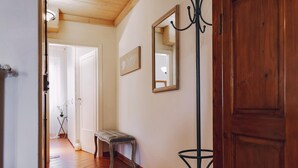 A hallway with a bench, a mirror, and a door. - Apartment 'Borgo Pinti 49' with Private Terrace, Wi-Fi and Air Conditioning (Florence)