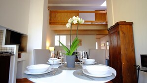 A dining area with a round table set for four, a potted plant, and a wooden ceiling. - Apartment 'Borgo Pinti 49' with Private Terrace, Wi-Fi and Air Conditioning (Florence)