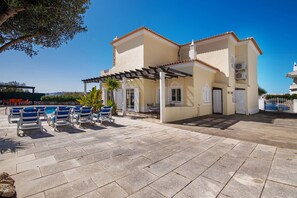 A two-story building with a covered patio area, outdoor seating, and a pool. - Holiday Home 'Breeze - Adults Only' with Sea View, Wi-Fi and Air Conditioning (Albufeira)