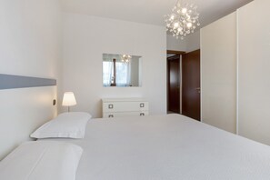 A bedroom with a bed, a dresser, a mirror, and a chandelier. - Holiday Home 'Casa Vacanze Da Ricky' with Shared Pool, Wi-Fi and Air Conditioning (Peschiera)