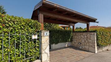 Ein begrenzter Eingang mit einer Steinmauer, einem Metallzaun und einer Pergola.