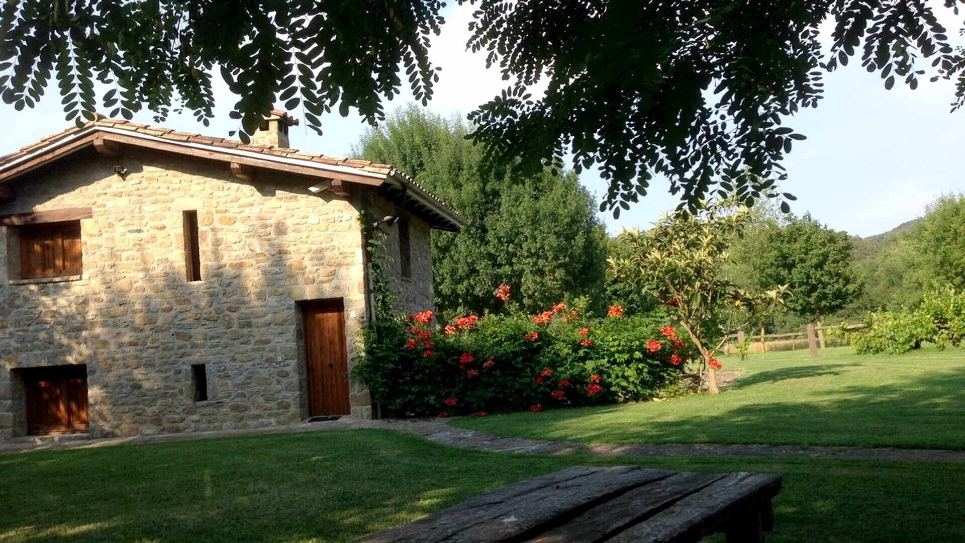 Un bâtiment en pierre avec un toit en pente, une porte en bois et une fenêtre.