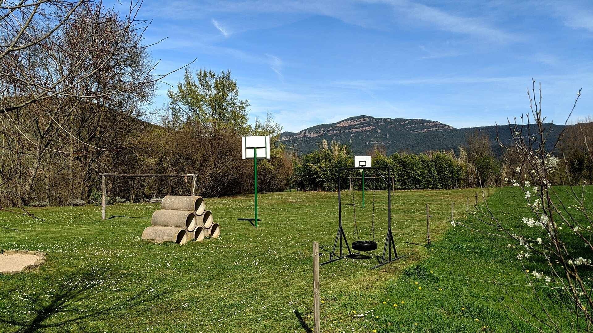 Un campo cubierto de césped con aros de baloncesto y una estructura de hormigón.