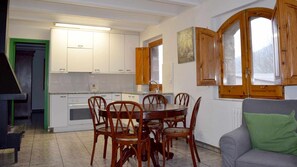 Un espace de vie compact comprenant un coin repas, une kitchenette et un canapé.