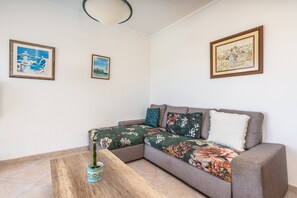Un salon avec un canapé, une table basse et une plante en pot.