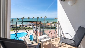 Ein Balkon mit Blick auf das Meer, einem Pool und einem Stuhl.