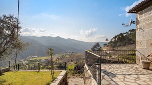 Una escalera de piedra que conduce a un balcón con vistas a un valle y montañas.