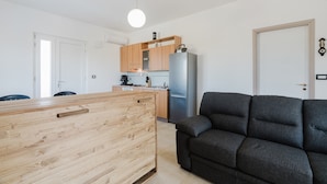 A modern kitchen with wooden cabinets, a built-in fridge, and a round ceiling light.