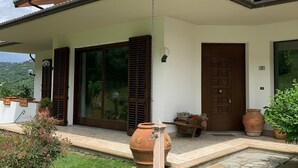 Ein Haus mit überdachter Veranda, einer großen Tür und einem steinernen Weg zum Eingang.