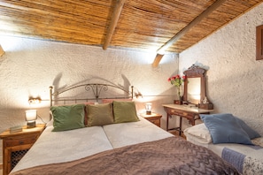 A bedroom with a bed, bedside tables, a nightstand, a mirror, and a wooden ceiling. - Chalet 'Can Pavet' with Mountain View, Private Pool and Wi-Fi (Pontons)