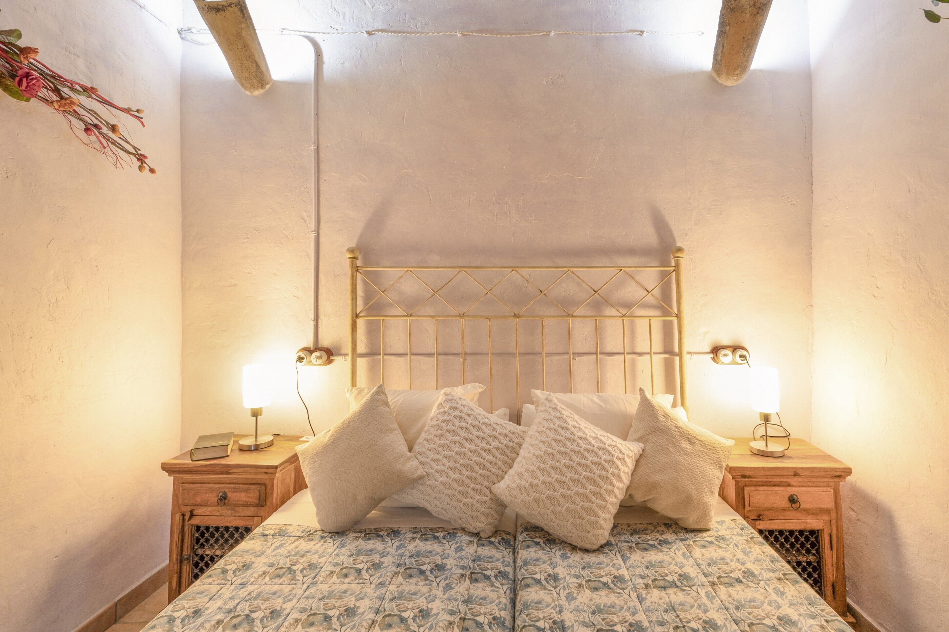 Une chambre à coucher avec un lit, deux tables de chevet et une petite table de nuit avec une lampe.