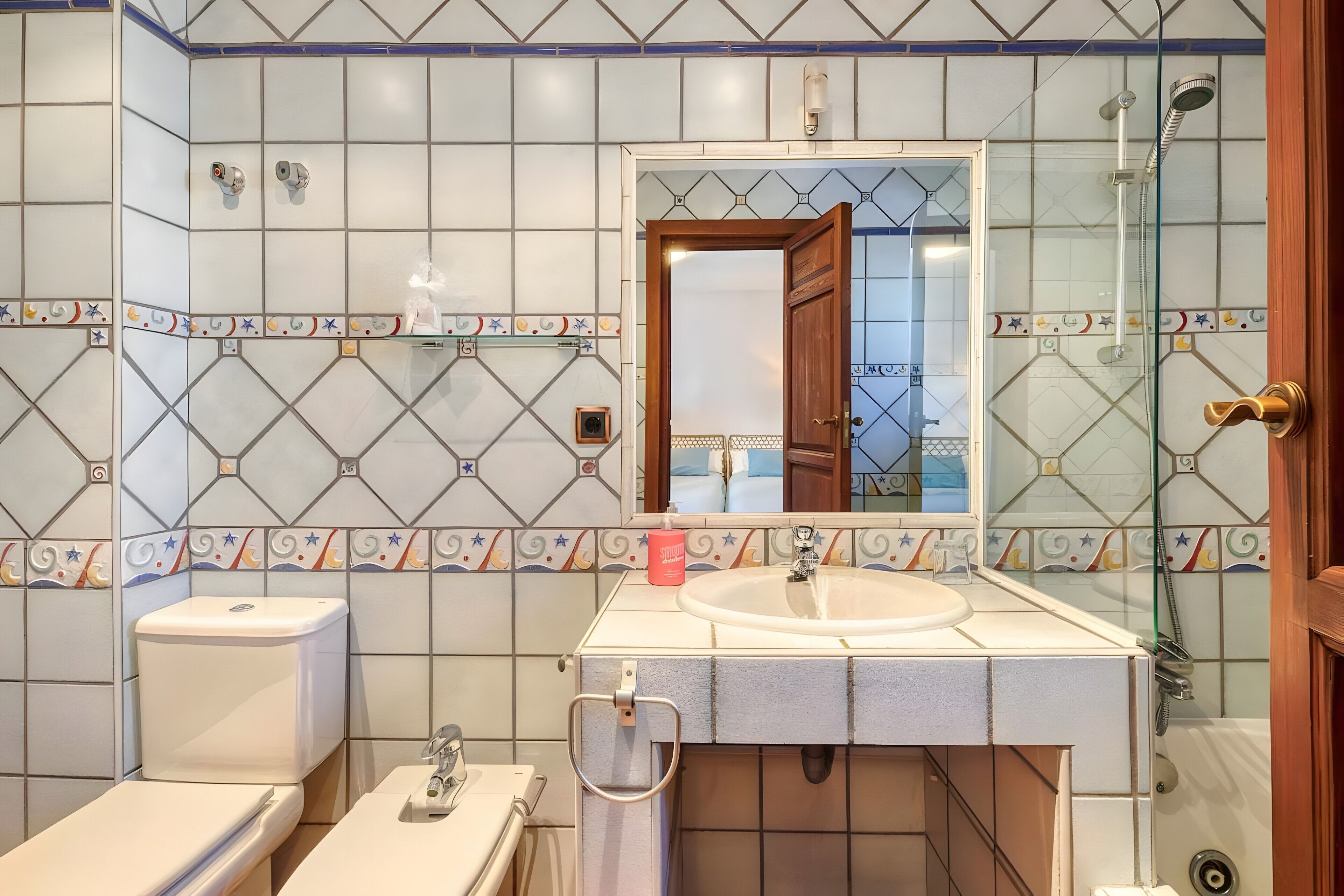 A bathroom with a toilet, sink, and shower.