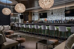Relax and socialize in our stylish bar area, featuring a long counter, comfortable seating, and modern pendant lights.