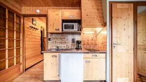 Eine Küche mit Holzausstattung, einer Mikrowelle und einem Kühlschrank.