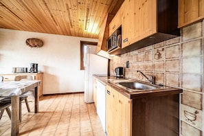A kitchen with wooden cabinets, a tiled backsplash, a sink, and a stove.