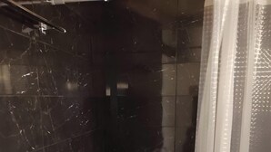 A bathroom with a shower, toilet, and marble tiles. - Studio Apartment 'Corfu Oasis' with Mountain View, Wi-Fi and Air Conditioning (Corfu)