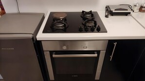 A compact kitchen with a PHILCO refrigerator, a built-in stove with four burners, and a small oven. - Studio Apartment 'Corfu Oasis' with Mountain View, Wi-Fi and Air Conditioning (Corfu)