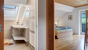 Un dormitorio con cama, ventana y vistas al exterior.