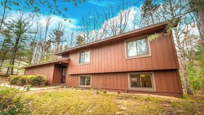 A two-story wooden house with a front porch, surrounded by trees. - Pets~Trails~Beaches~10mins to TC~2 Person Suite (Williamsburg)