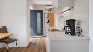 A modern kitchen with a built-in stove, a coffee maker, and a sink.