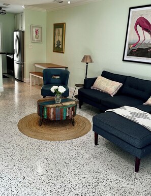 Relax in a cozy living room with a comfortable sofa, dining area, and kitchen space.