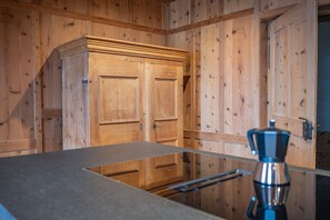 Un interno in legno con un bancone cucina, mobili e una macchina per il caffè.