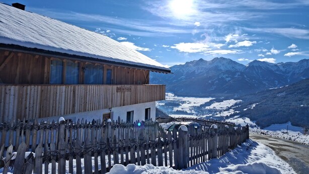 A wooden building with a sign 'PEINTNER' and a snow-covered landscape with mountains in the background. - Apartment 'Peunt' with Mountain View, Shared Terrace and Wi-Fi (Percha BZ)