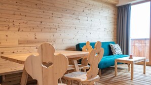 A wooden interior with a dining table, chairs, a sofa, and a small table with a candle. - Apartment 'Peunt' with Mountain View, Shared Terrace and Wi-Fi (Percha BZ)