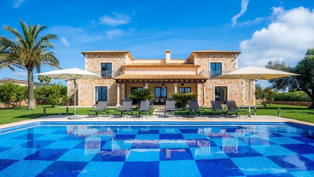 A pool with a checkered pattern, a stone building with balconies, and outdoor seating. - Country House 'Fortuna' with Mountain View, Private Pool and Wi-Fi (Manacor)