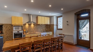 A modern kitchen with a central island, wooden cabinets, and a stone backsplash. - Villa 'Hamlet' with Private Pool, Private Terrace and Wi-Fi (LABLACHÈRE)