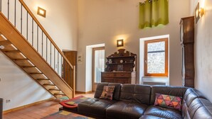 A living room with a staircase, a sofa, a coffee table, and a wooden cabinet. - Villa 'Hamlet' with Private Pool, Private Terrace and Wi-Fi (LABLACHÈRE)