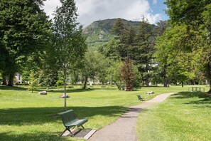 Un parc avec un banc, un sentier et des arbres.