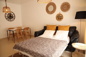Un dormitorio con cama, escritorio y sillas.