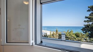 Une fenêtre donnant sur la mer et un balcon avec des balustrades.