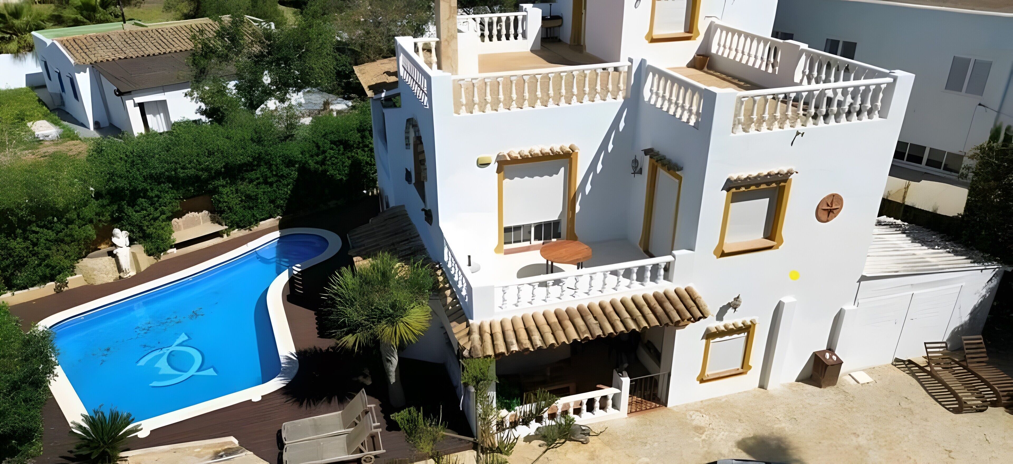 Un edificio de varios pisos con piscina, balcones y un jardín.