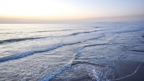A beach with waves approaching the shore.