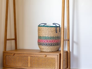 A woven basket with colorful patterns on a wooden chair.