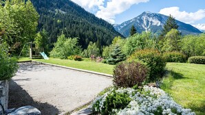 A mountain landscape with a playground and a gravel area. - Apartment 'Roméo' with Mountain View, Private Terrace and Shared Garden (Champagny-en-Vanoise)