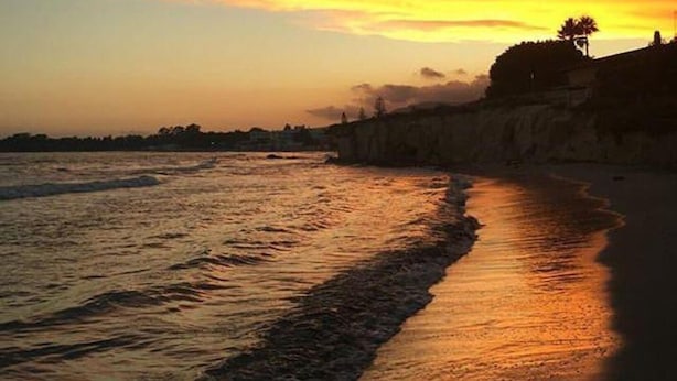 A beach with a sunset, waves, and a distant shoreline. - Villa 'Morgana' with Private Terrace, Wi-Fi and Air Conditioning (Fontane Bianche)