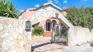 A house with a stone wall, a mailbox, a gate, and a staircase leading to the entrance. - Villa 'Morgana' with Private Terrace, Wi-Fi and Air Conditioning (Fontane Bianche)
