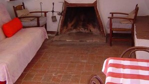 A room with a fireplace, a sofa, a chair, and a table.