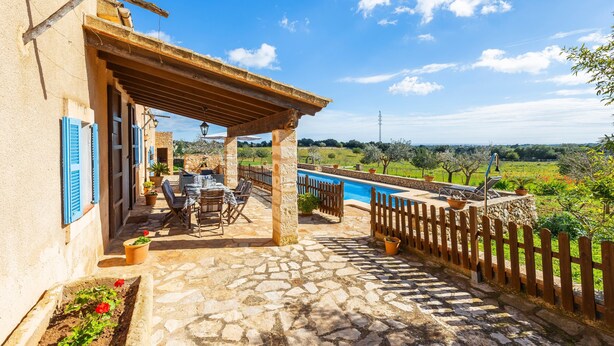 A stone patio with outdoor furniture, a pool, and a view of the countryside. - Villa 'Pascual Gran' with Mountain View, Private Pool and Wi-Fi (Manacor)