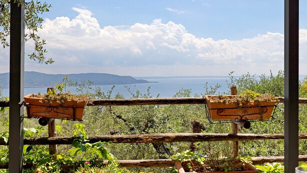 Une pergola en bois offrant une vue sur la mer et les montagnes.