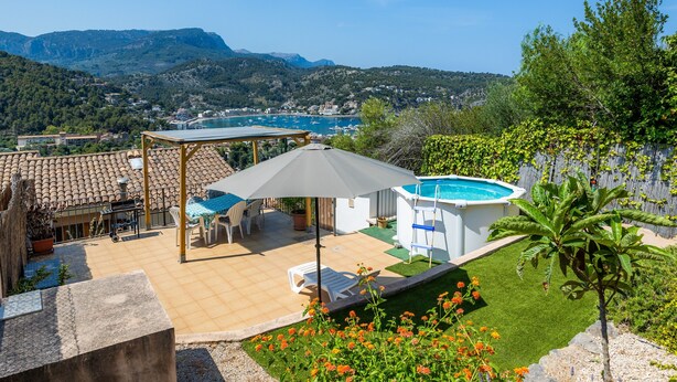 A patio with a table and chairs, a pool, and a view of the mountains. - Apartment 'Sa Torreta Luxury Views' with Sea View, Private Terrace and Wi-Fi (Sóller)
