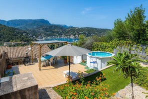 A patio with a table and chairs, a pool, and a view of the mountains. - Apartment 'Sa Torreta Luxury Views' with Sea View, Private Terrace and Wi-Fi (Sóller)