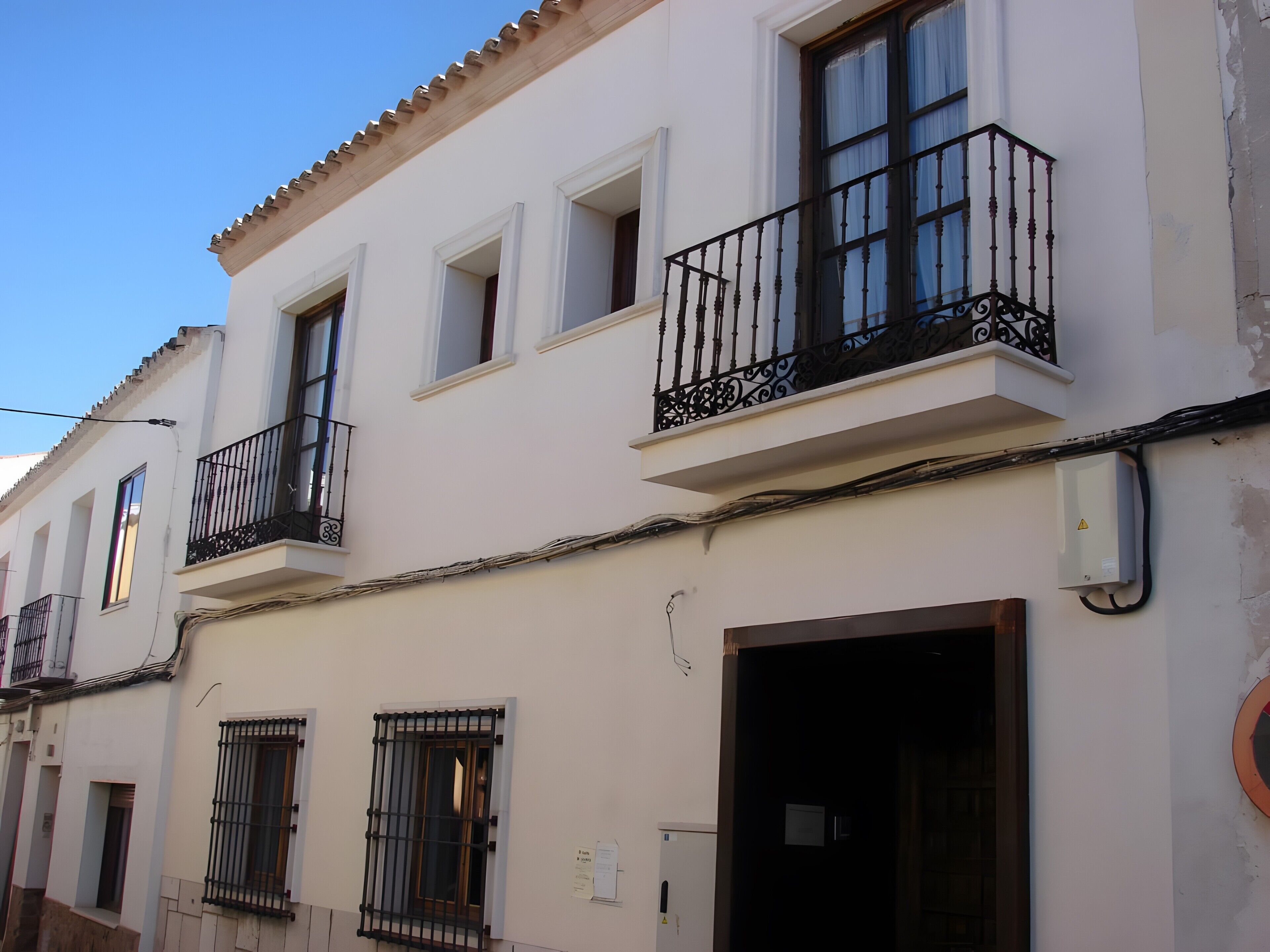 Un edificio con varios balcones, una puerta y ventanas.