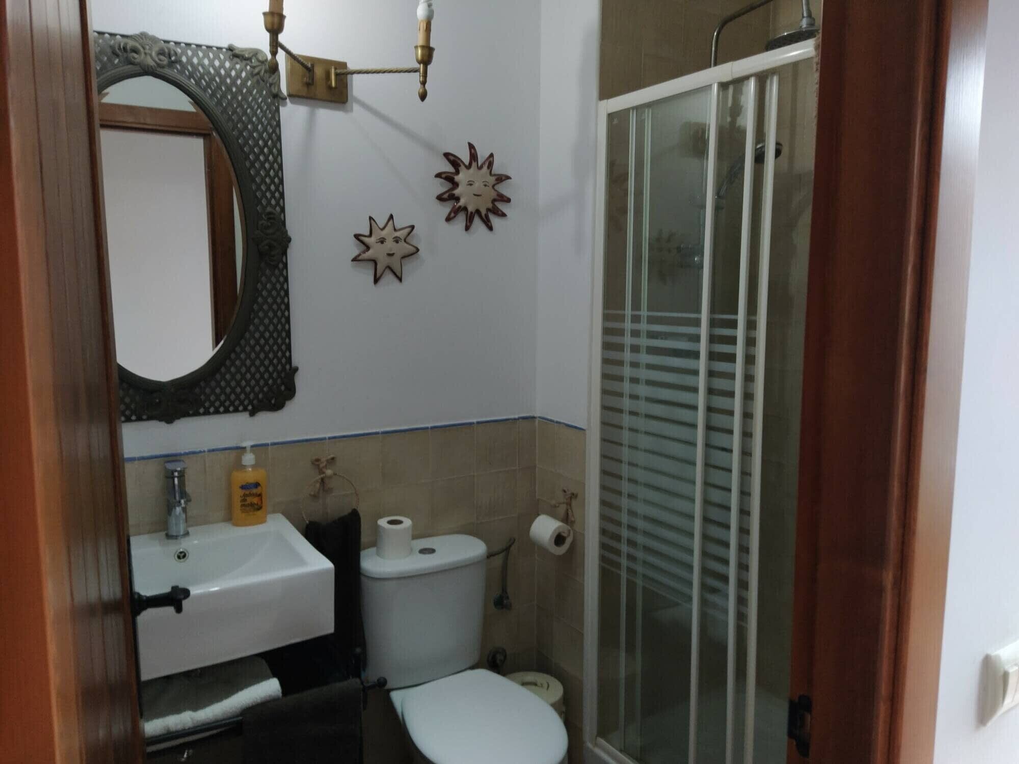 Un baño con lavamanos, inodoro y ducha.