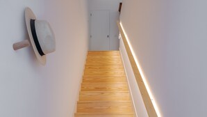 Una escalera de madera con una lámpara en la pared.